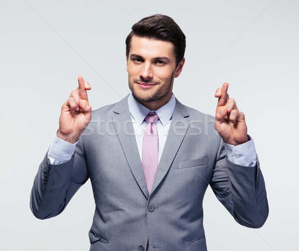 Businessman with fingers crossed Stock photo © deandrobot