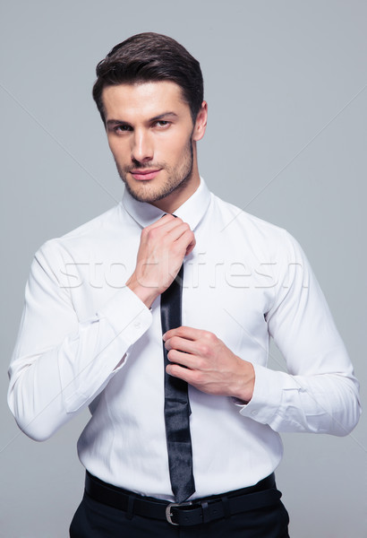 Jóképű üzletember nyakkendő szürke néz kamera Stock fotó © deandrobot