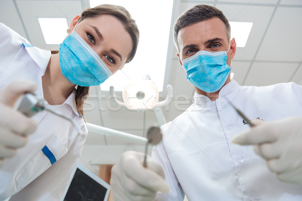 Dos dentistas tratamiento paciente clínica Foto stock © deandrobot