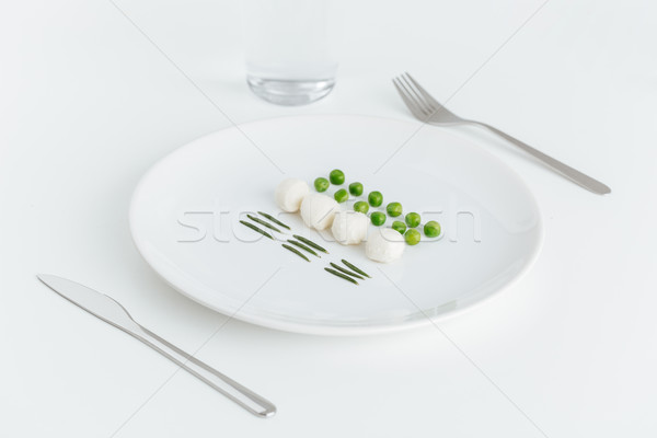Green peas, rosemary and balls of mozzarella on the plate Stock photo © deandrobot