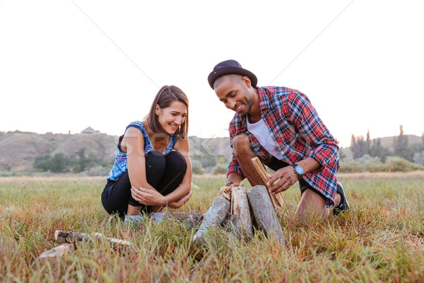 Multiethnic couple making campfire outdoors together Stock photo © deandrobot