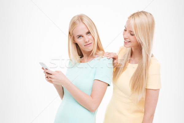Young beautiful lady looking at the friend's phone Stock photo © deandrobot