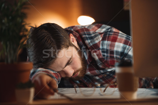 Tired bearded designer sleeping in office late at night Stock photo © deandrobot