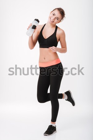 Portrait souriant jeunes femme de remise en forme une bouteille d'eau [[stock_photo]] © deandrobot