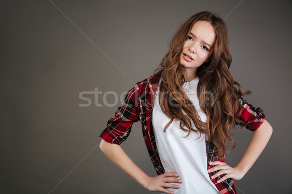 Unhappy pretty young woman standing with hands on waist Stock photo © deandrobot