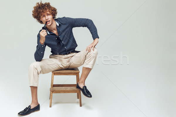 Handsome retro man dressed in shirt sitting and posing Stock photo © deandrobot