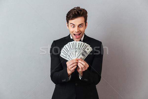 Screaming man in official suit holding money. Stock photo © deandrobot