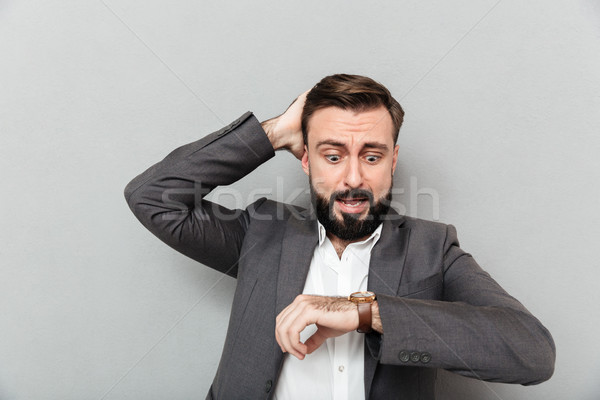 Horizontal image of astonished man looking at wrist watch, touch Stock photo © deandrobot