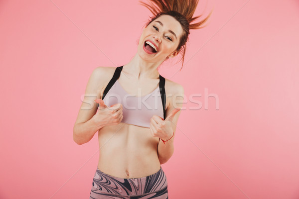 Cheerful sportswoman running and showing thumbs up Stock photo © deandrobot