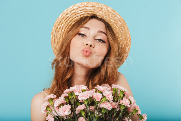 Cute caucasian woman holding flowers blowing kisses. Stock photo © deandrobot