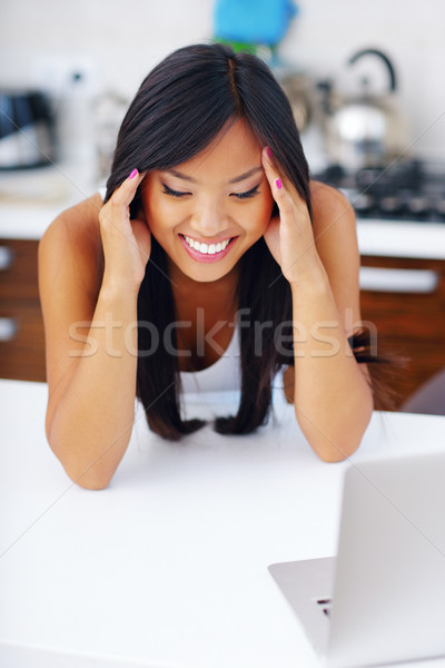 Young happy asian woman at home Stock photo © deandrobot