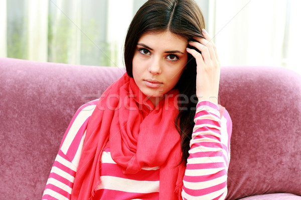 Young pensive woman touching her hair at home Stock photo © deandrobot