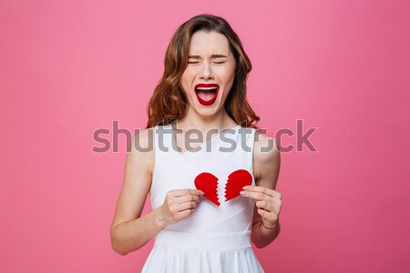 Stock photo: Surprised woman holding red heart