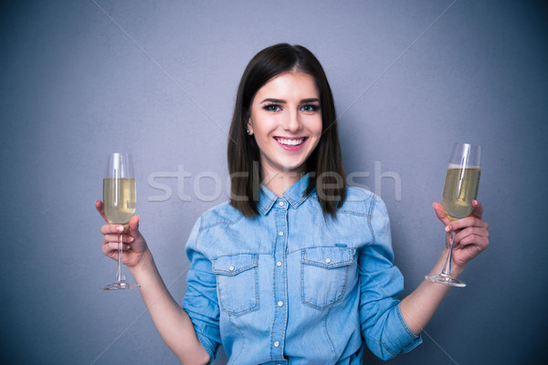 Smiling woman holding two glass of champagne Stock photo © deandrobot