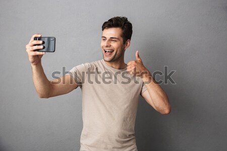 Cheerful sports man making selfie photo on smartphone Stock photo © deandrobot