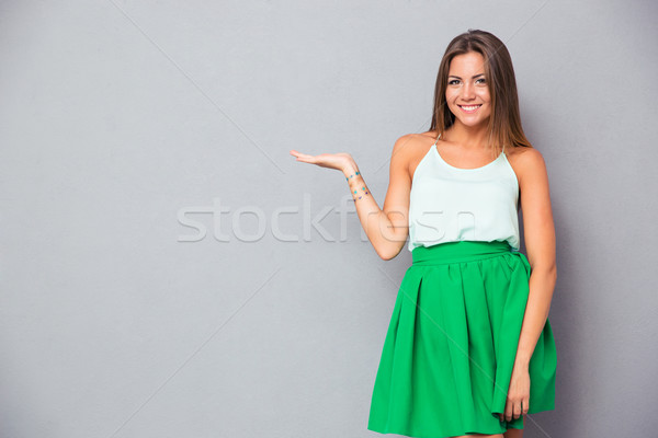 Stock photo: Smiling pretty girl holding copyspace on the palm