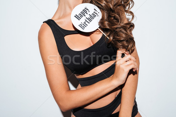 Cropped image of girl in bikini holding sign on stick Stock photo © deandrobot