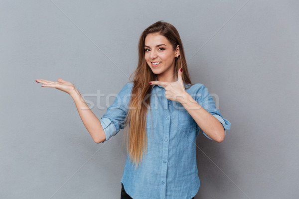 Woman holding invisible copyspace on the pound Stock photo © deandrobot