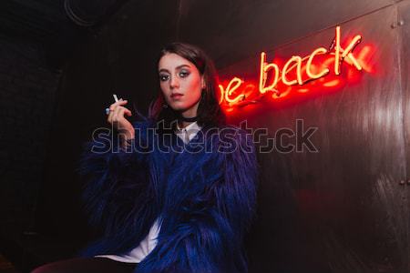 Stock photo: Woman holding human skull over background with glowing inscription
