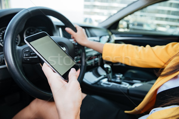 Stock photo: Close up image with female driver and blank phone screen