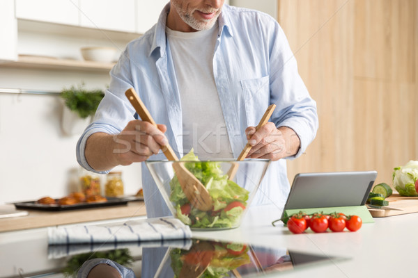 Görüntü olgun adam pişirme salata tablet ayakta Stok fotoğraf © deandrobot