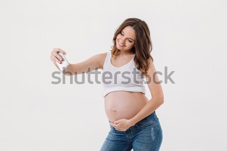 Happy pregnant woman make selfie with her belly Stock photo © deandrobot