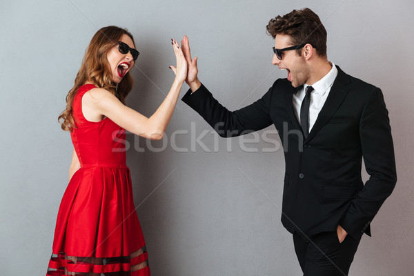 Portrait of a cheerful young couple dressed in formal wear Stock photo © deandrobot