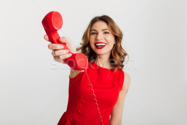 Portrait of a smiling young woman dressed in red dress Stock photo © deandrobot