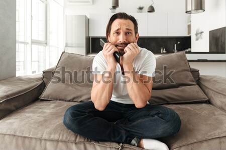 Shocked excited young woman watch TV. Stock photo © deandrobot