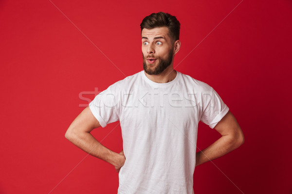 Excited young handsome man looking aside. Stock photo © deandrobot