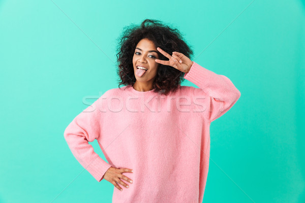 Photo of amusing woman in pink shirt sticking out tongue and sho Stock photo © deandrobot