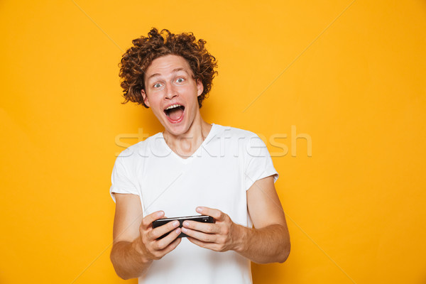 Caucasian gamer man in casual t-shirt playing online video games Stock photo © deandrobot