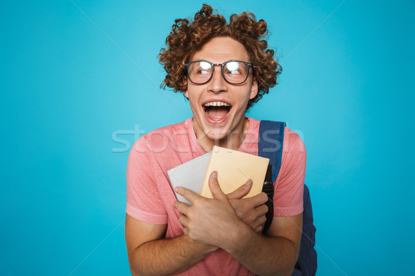 Photo of nerd student guy with curly hair wearing glasses and ba Stock photo © deandrobot