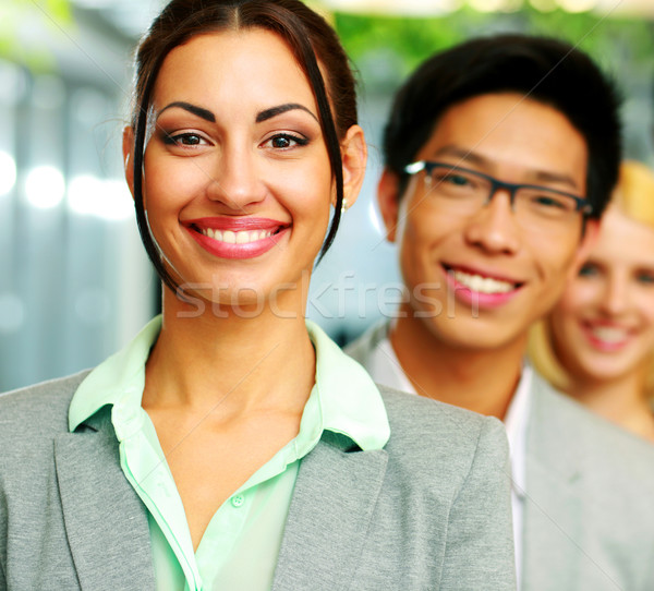 Cheerful businesswoman standing in front of colleagues Stock photo © deandrobot