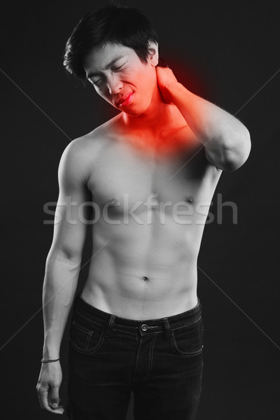 Asian man suffering from neck pain on black background Stock photo © deandrobot