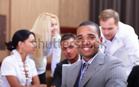 Multi ethnic business team at a meeting. Interacting. Focus on woman Stock photo © deandrobot