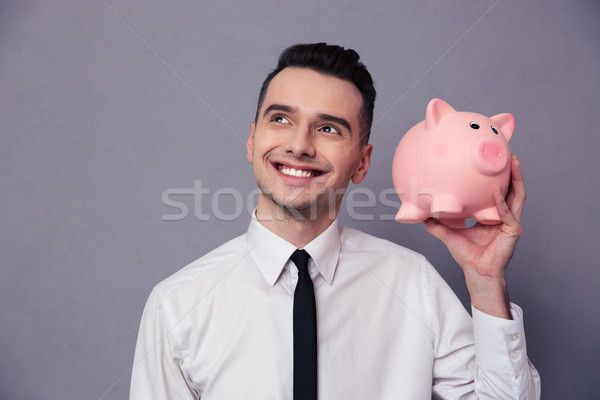 Happy businessman holding pig money box Stock photo © deandrobot