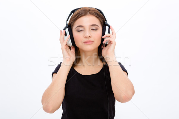 Relaxed serene pretty young woan listening to musi using headphones Stock photo © deandrobot