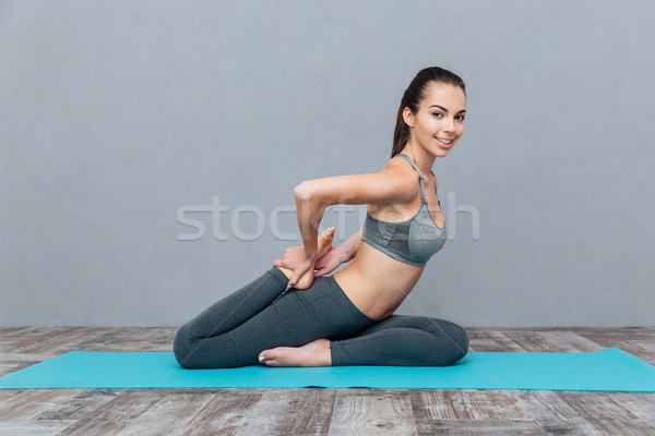 Young girl doing yoga exercise one legged king pigeon Stock photo © deandrobot