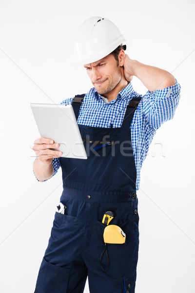 Confused builder in helmet scratching his head and holding tablet Stock photo © deandrobot