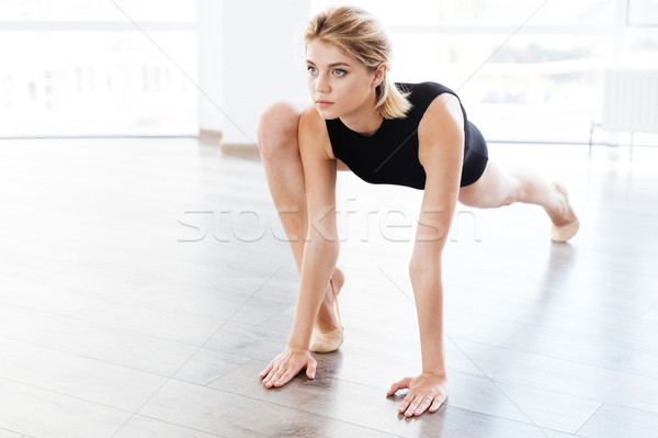 Woman ballerina stretching legs in dance class Stock photo © deandrobot