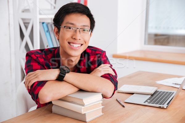 Cheerful student guy has leaned the elbows on books Stock photo © deandrobot