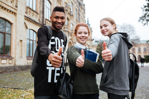 Group of students standing outside and showing thumbs up Stock photo © deandrobot