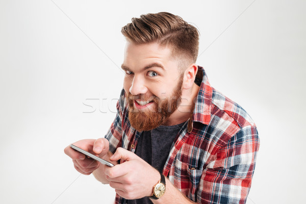 Stock photo: Funny man in shirt playing game on his smart phone