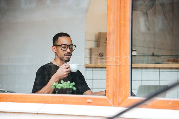 Portrait of a young african man drinking coffee Stock photo © deandrobot