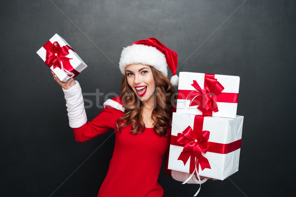 Happy woman in red christmas dress holding stack of presents Stock photo © deandrobot