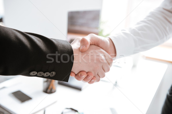 Cropped photo of handsome businessmen shake their hands. Stock photo © deandrobot