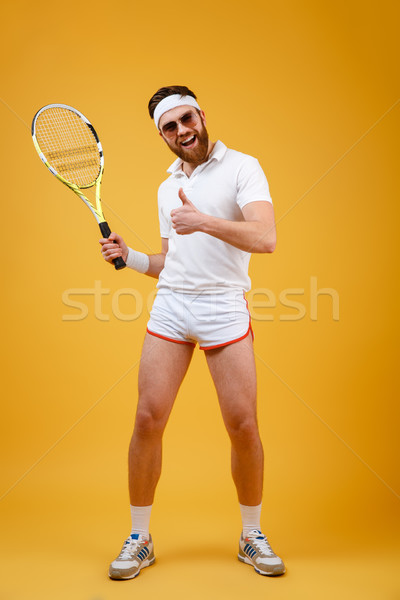 Vertical image of sportsman with tennis racquet showing thumb up Stock photo © deandrobot