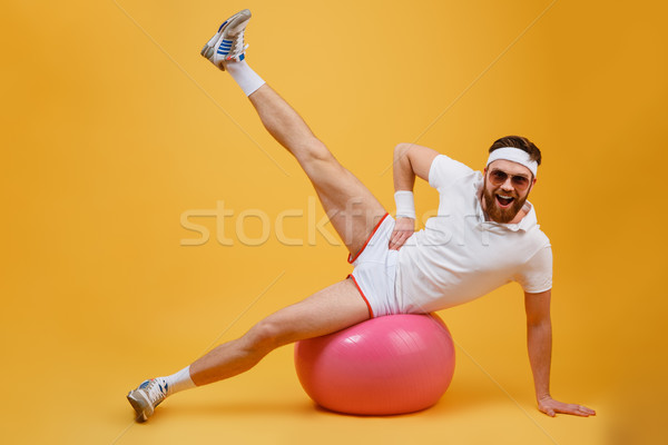 Happy Sportsman Engaged in aerobics on fitness ball Stock photo © deandrobot
