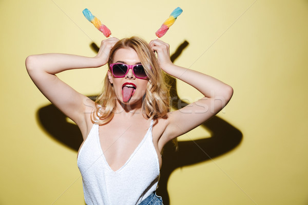 Young lady with bright lips makeup showing tongue Stock photo © deandrobot